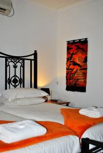 a bedroom with two beds and a painting on the wall at Mount Azimbo Lodge in Louis Trichardt