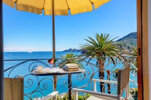 a balcony with a table and an umbrella and the ocean at Hotel Continental in Santa Margherita Ligure