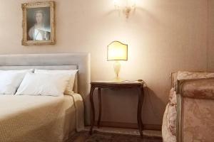 a bedroom with a bed and a lamp on a table at Apartment Rigoletto San Marco Square in Venice