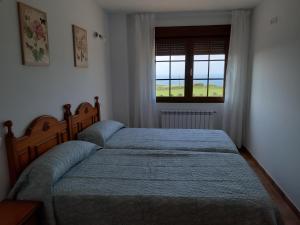 - une chambre avec 2 lits et une fenêtre dans l'établissement APARTAMENTOS EL SOLO, à Santillana del Mar