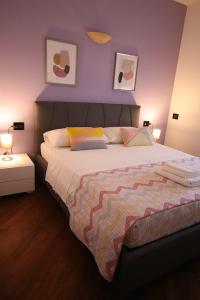 - une chambre avec un grand lit et un mur pourpre dans l'établissement La Casetta BG, à Bergame