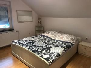 um quarto com uma cama com um cobertor preto e branco em Tri šešira Ljubovija em Ljubovija