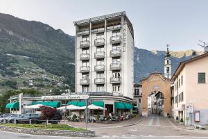 een groot gebouw met een café ervoor bij Hotel Conradi in Chiavenna