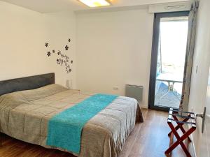 1 dormitorio con cama y ventana grande en Les Terrasses de l'Océan en Saint-Hilaire-de-Riez