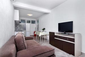 a living room with a couch and a flat screen tv at Apartmani Nikola in Zastražišće