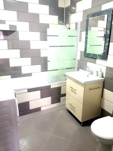 a bathroom with a toilet and a sink and a mirror at Skyline Rooftop Condos in Oradea