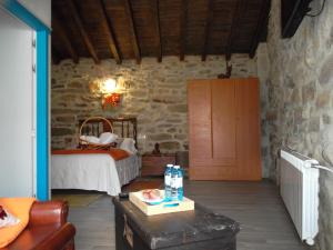 1 dormitorio con 1 cama en una pared de piedra en Casa Antoni@, en Parada del Sil