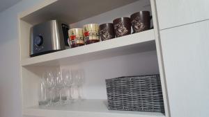 a cupboard with glasses and wine glasses on it at Alex Marina flat in Mamaia