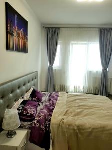a bedroom with a bed and a window at Skyline Rooftop Condos in Oradea