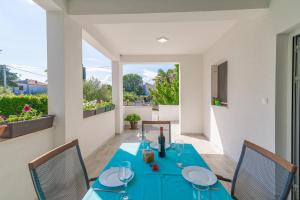 uma sala de jantar com uma mesa azul e cadeiras em Apartments Coronata em Biograd na Moru