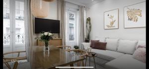 - un salon avec une table et un canapé dans l'établissement Amazing and new apartment five minutes from gran via, à Madrid