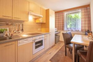 a kitchen with wooden cabinets and a table and a dining room at Bella-Vista Apart Sölden in Sölden