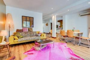 a living room with a yellow couch and a pink rug at Un tour en Arles in Arles +20 photos