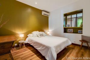 a bedroom with a white bed and a green wall at Un tour en Arles in Arles