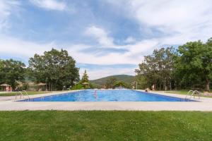 a swimming pool in a park with trees and a sky at Jaza Paraiso in Cercedilla