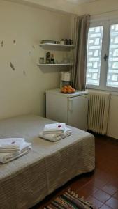 een slaapkamer met een bed met handdoeken erop bij A Cozy Affordable Place at Voula in Athene