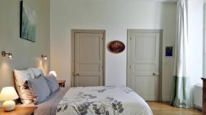 ein Schlafzimmer mit einem Bett und zwei weißen Türen in der Unterkunft Le Clos des Roseaux in Chorey-lès-Beaune