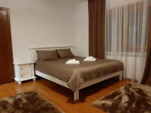 a bedroom with a bed with two towels on it at Vila Confort in Borşa