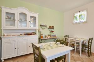 a kitchen with white cabinets and a table and chairs at Agriturismo Casastella in Ceriale