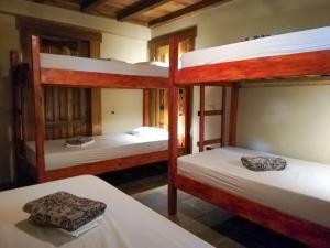 a room with three bunk beds in a house at Bodhi Santa Catalina in Santa Catalina