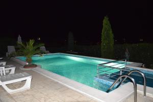 a swimming pool in a yard at night at Villa Vega in Sozopol