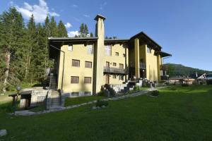 ein großes Gebäude mit einem Rasenplatz davor in der Unterkunft Vagliana appartamento in Madonna di Campiglio