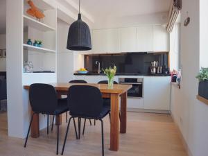 a kitchen with a wooden table and black chairs at Inselloft Rügen - Meerblick, Pool & eigener Strandzugang in Binz +39 photos