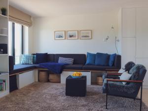 a living room with a blue couch and a chair at Inselloft Rügen - Meerblick, Pool & eigener Strandzugang in Binz