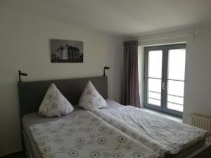 a bedroom with a bed with pillows and a window at Pension am Pferdemarkt in Güstrow