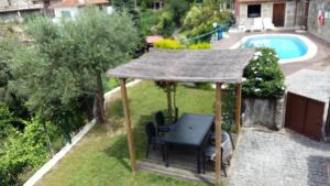 a gazebo with a table and chairs and a pool at Chalé da Fonte - T2 in Geres