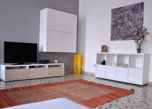 a living room with a television and white cabinets at Casa Rosetta in Palermo