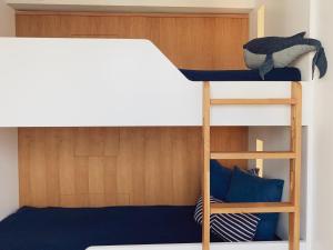 a bunk bed with a ladder next to a bunk bed at Inselloft Rügen - Meerblick, Pool & eigener Strandzugang in Binz