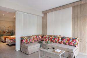 a living room with a couch with colorful pillows at Alexandra Beach Spa Resort in Potos