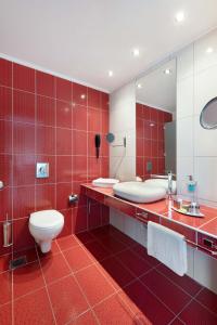 a red bathroom with a toilet and a mirror at Alexandra Beach Spa Resort in Potos