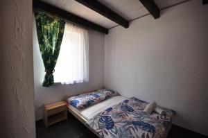 - une petite chambre avec un lit et une fenêtre dans l'établissement Apartamenty pod Skałą, à Polańczyk