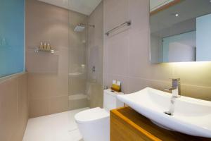 a bathroom with a sink and a toilet and a mirror at Chi Samui Resort in Bophut