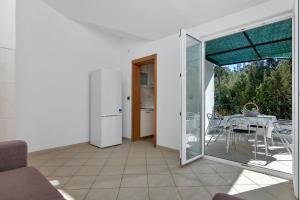 sala de estar con mesa y puerta de cristal en Apartments Rubin en Zastražišće