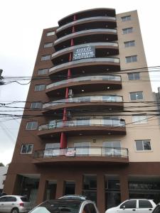 un edificio alto con coches estacionados frente a él en Mandala - El Palomar en El Palomar