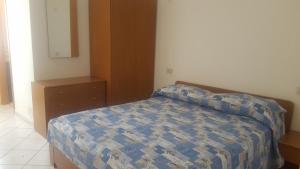 a bedroom with a bed with a blue comforter at Appartamento Il Mandarino in Pomonte