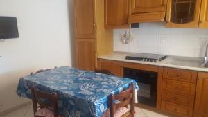 Appartamento Il Mandarino في بومونته: مطبخ مع طاولة عليها قطعة قماش من الطاولة الزرقاء