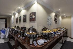a buffet line with many different types of food at Aguas do Iguaçu Hotel Centro in Foz do Iguaçu