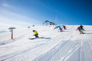 a group of people skiing down a snow covered slope at Souterrain Apartment Flachau in Flachau