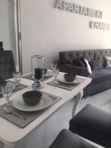 a living room with a table and a couch at Apartament Chanel Centrum in Malbork