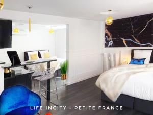 a bedroom with a king sized bed and a desk at LİFE İNCİTY - Petite France By Life Renaissance in Strasbourg