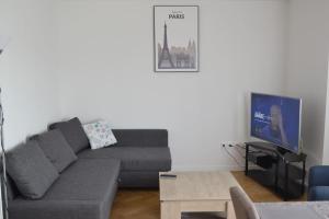 a living room with a couch and a tv at DISNEYLAND PARIS like home in Serris