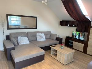salon z kanapą i stołem w obiekcie Martina Apartmanház w mieście Balatonlelle