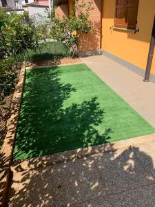 a patch of green grass in front of a house at Trilocale in villetta piano terra indipendente in Osio Sotto