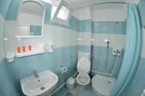 baño azul y blanco con aseo y lavamanos en Vila Aty & Michelle, en Vama Veche