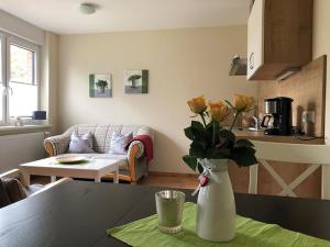 a living room with a table with a vase of flowers at Ferienwohnung am Storchennest in Schnackenburg