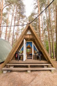 une tente encadrée avec une terrasse couverte dans les bois dans l'établissement Toolse Puhkeküla, à Toolse